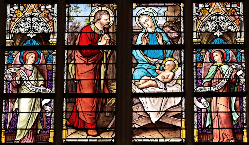 Vitrail d une église diffusant une lumière colorée, support traditionnel des scènes de la Nativité