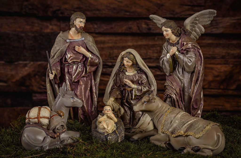 Santons et figurines disposés autour de la mangeoire dans une crèche de Noël