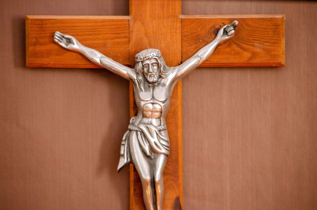 Crucifix de bois dans la pénombre d'une église, évoquant le supplice de sainte Julie
