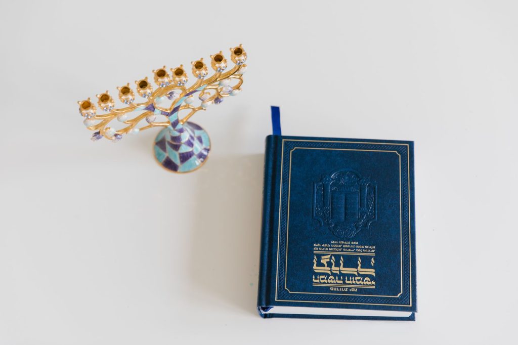 Menorah à sept branches posée près d’un livre hébraïque