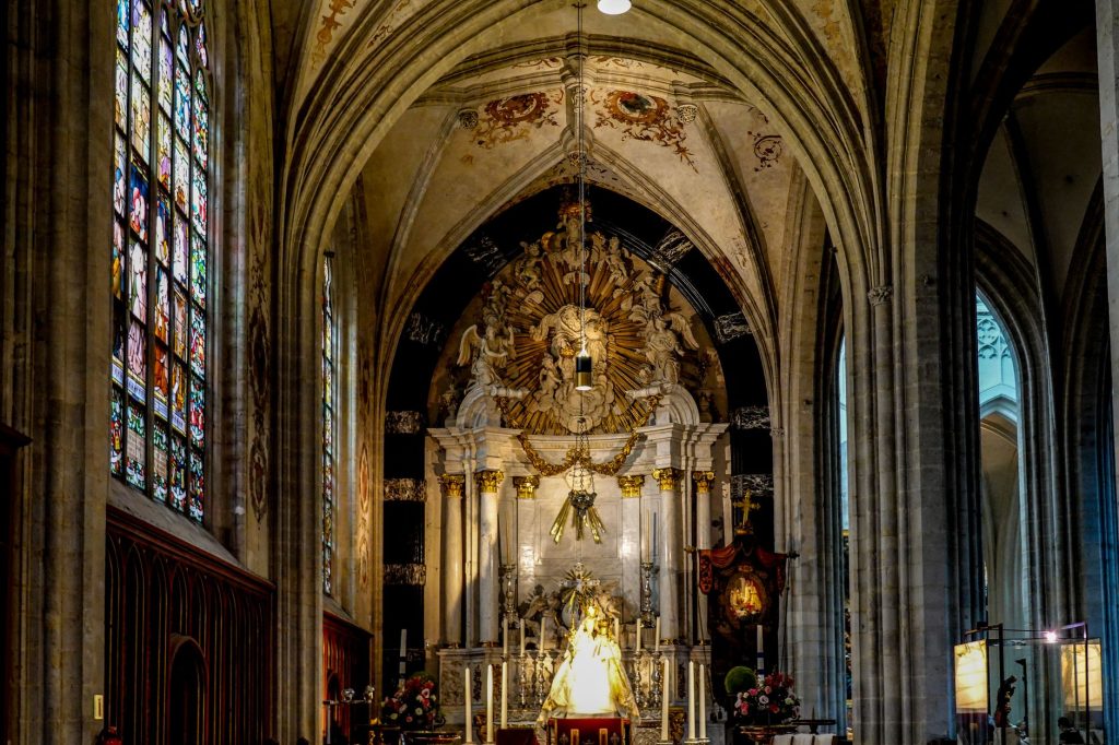 Intérieur d'une cathédrale gothique avec autel orné et vitraux