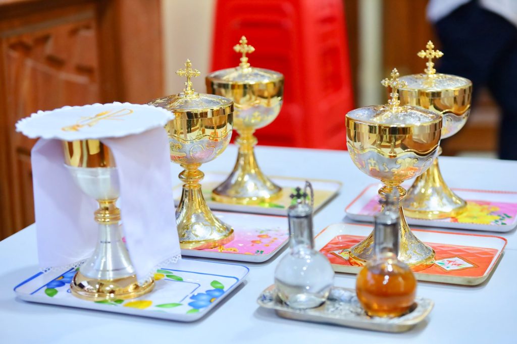 Calices et vases sacrés dorés disposés sur un autel pour la célébration eucharistique