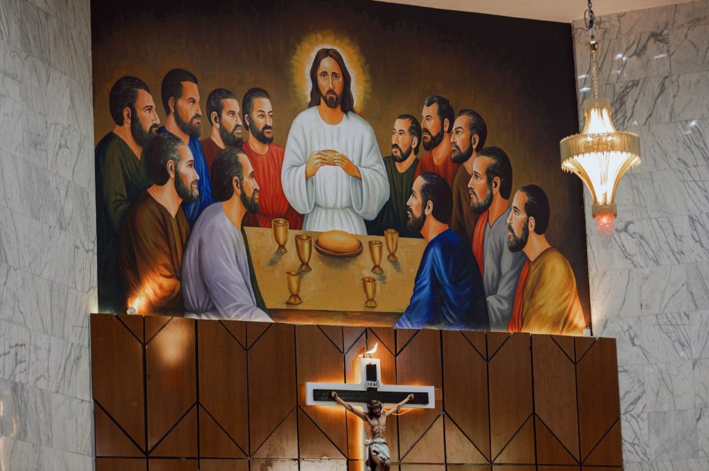 Grande fresque murale représentant la Cène dans une église, surmontée d’un crucifix