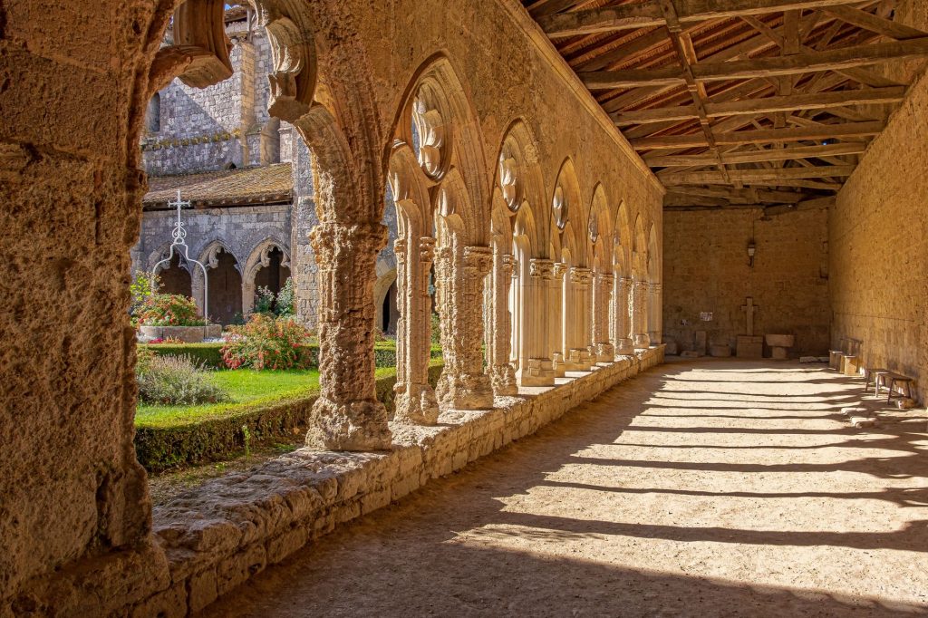 Cloître monastique médiéval baigné de lumière, cadre de la vie régulière que rejoignit Judicaël
