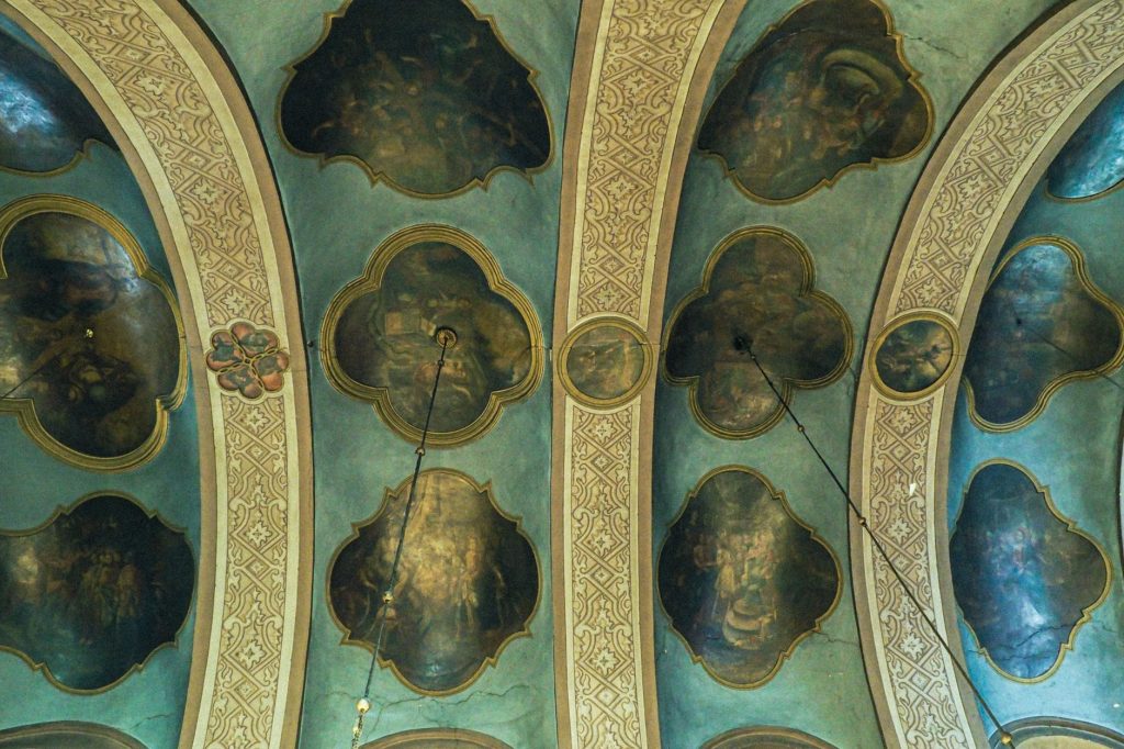 Plafond d'église couvert de fresques et d'arcs ornés