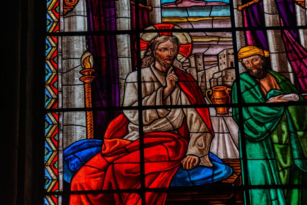 Vitrail de cathédrale représentant le Christ, la lumière traversant le verre coloré