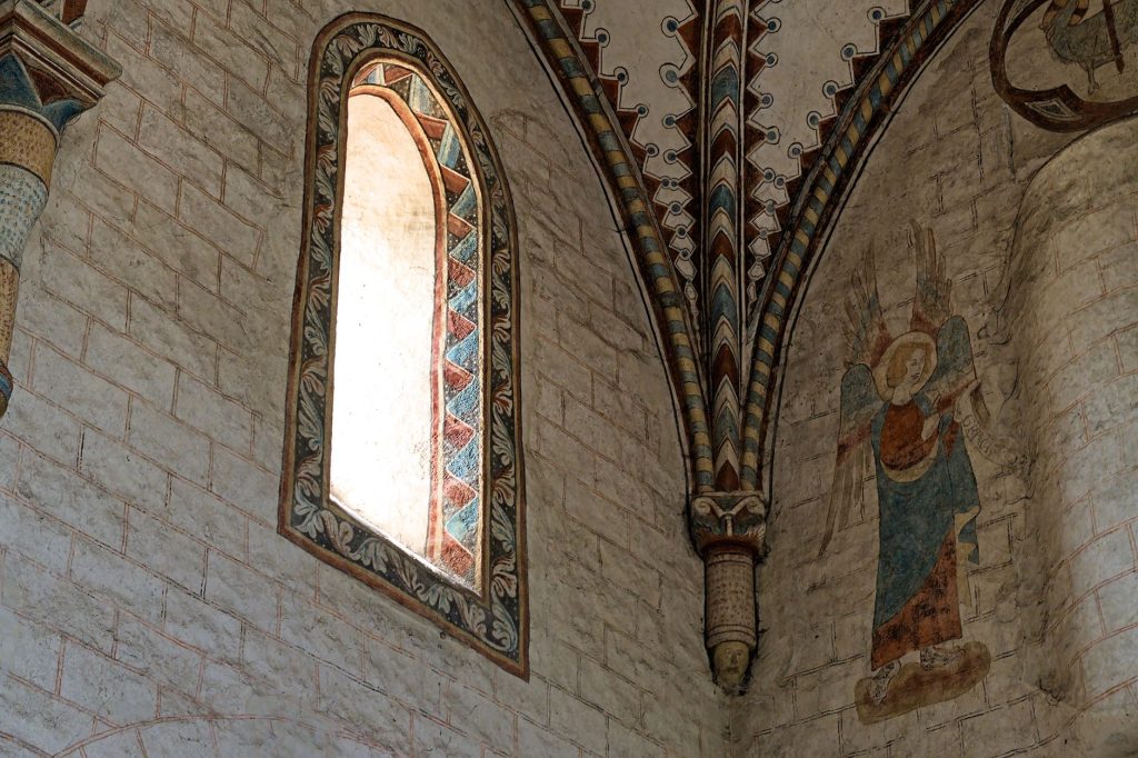 Intérieur d'église gothique orné de fresques et de vitraux, art sacré européen du Moyen Âge tardif