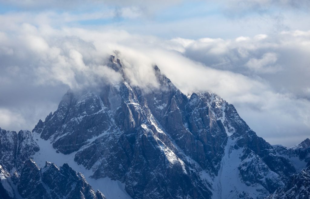 Sommets alpins enneigés émergeant des nuages dans les Dolomites italiennes