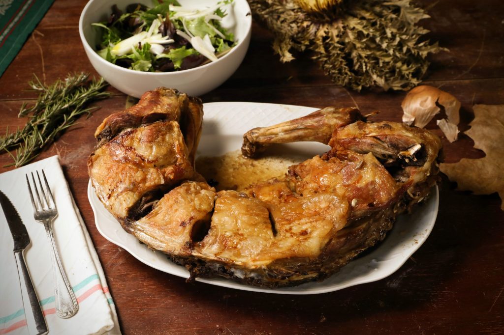 Gigot d’agneau rôti servi sur un plat, tradition du repas de Pâques
