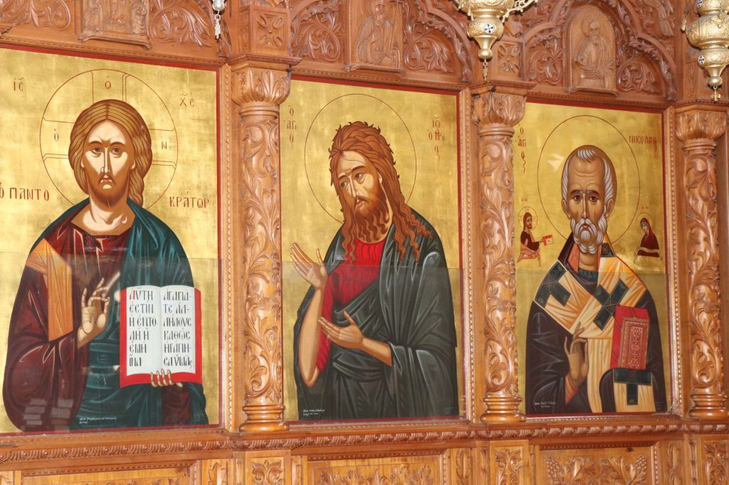 Panneaux d’icônes peintes alignés sur une paroi de bois dans une église orthodoxe