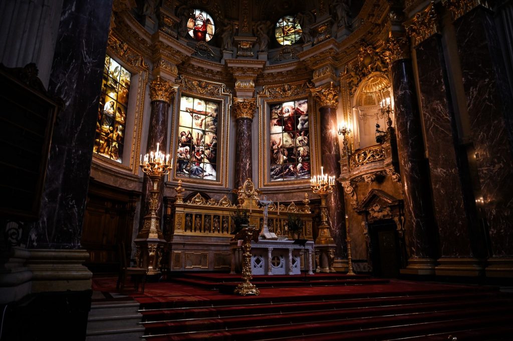 Intérieur d'église baroque orné de dorures et de vitraux, typique de l'art de la Contre-Réforme