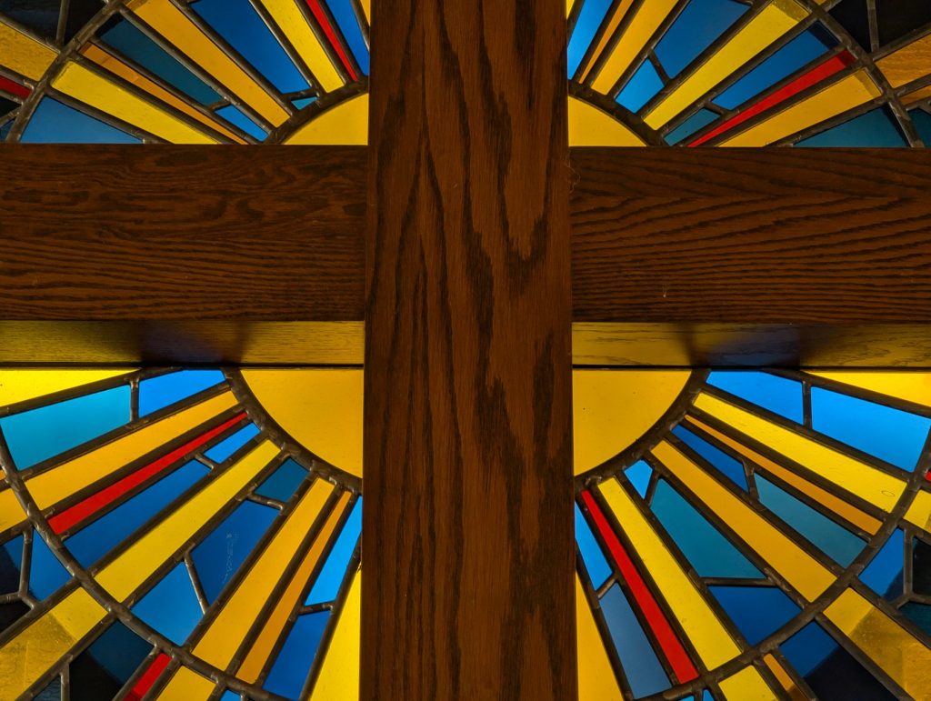 Vitrail coloré représentant une croix de bois dans une église