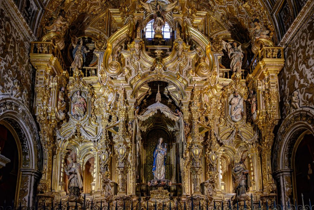 Retable baroque sculpté et doré dans une cathédrale espagnole, illustrant l’art sacré hérité des sièges épiscopaux andalous
