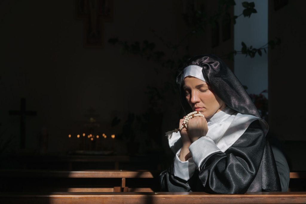 Religieuse en prière tenant un chapelet dans une église, évocation de la vie claustrale dominicaine